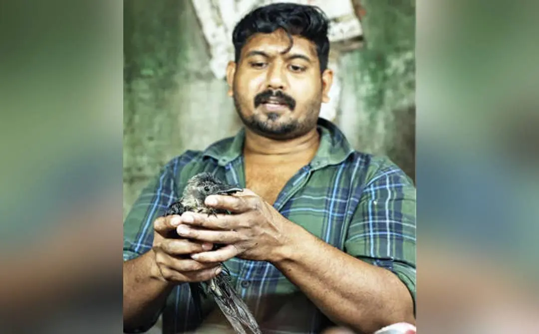 കൊക്ക് ശരിയാക്കിയ കാക്കയുമായി മലപ്പുറം കോട്ടപ്പടി മാർക്കറ്റിലെ റിയാസ് കോയിക്കോടൻ