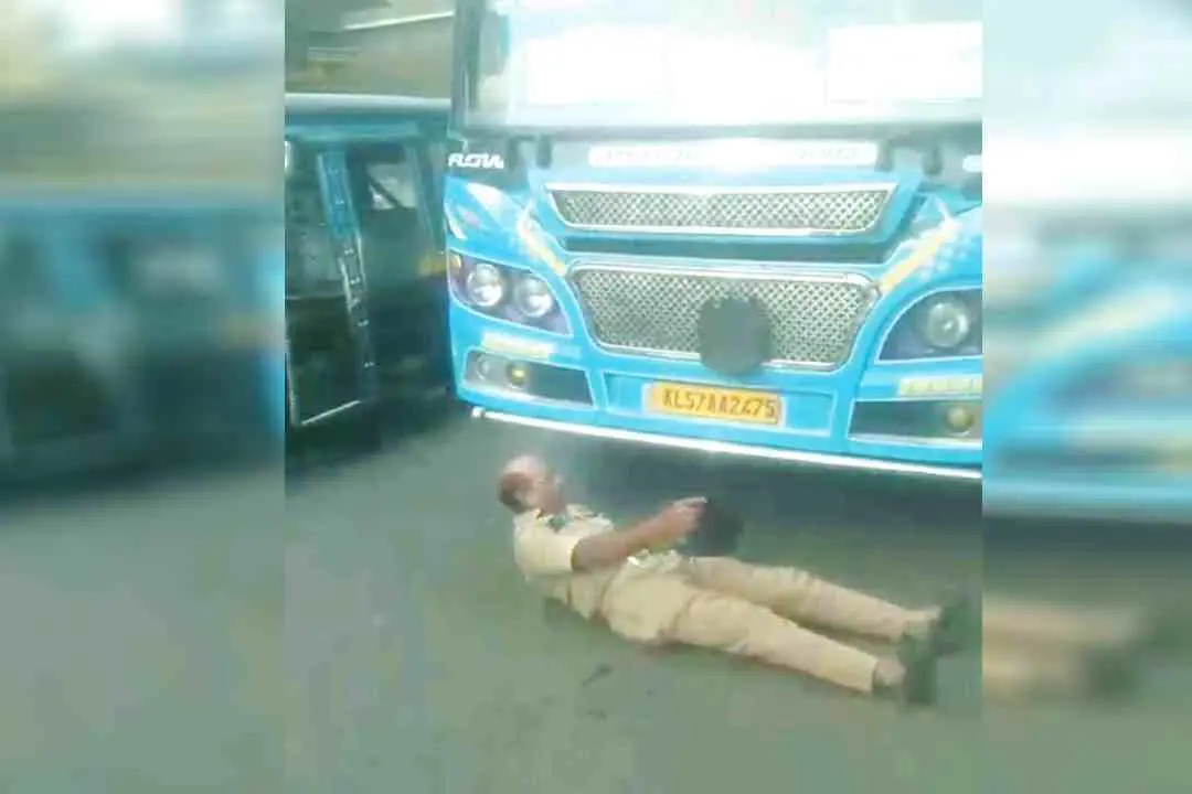 ഹോം ഗാർഡ് നാഗരാജൻ ബസിനുമുന്നിൽ കിടന്ന് പ്രതിഷേധിക്കുന്നു