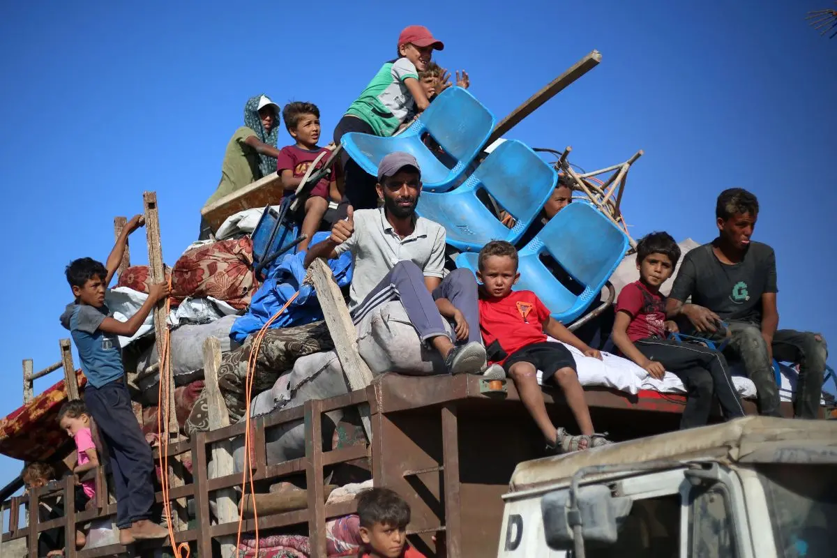 Displaced Palestinians move with their belongings southwards on a road in the Nuseirat refugee camp area in the central Gaza Strip following renewed Israeli evacuation orders for Gaza City on September 16, 2025 | Photo: AFP