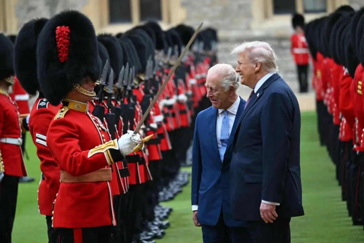Britain's King Charles III (C) and US President Donald Trump (R) talk with a Coldstream Guardsman as they inspect the guard of honour during a ceremonial welcome in the Quadrangle at Windsor Castle, in Windsor, on September 17, 2025, during the US president's second State Visit | Photo: AFP