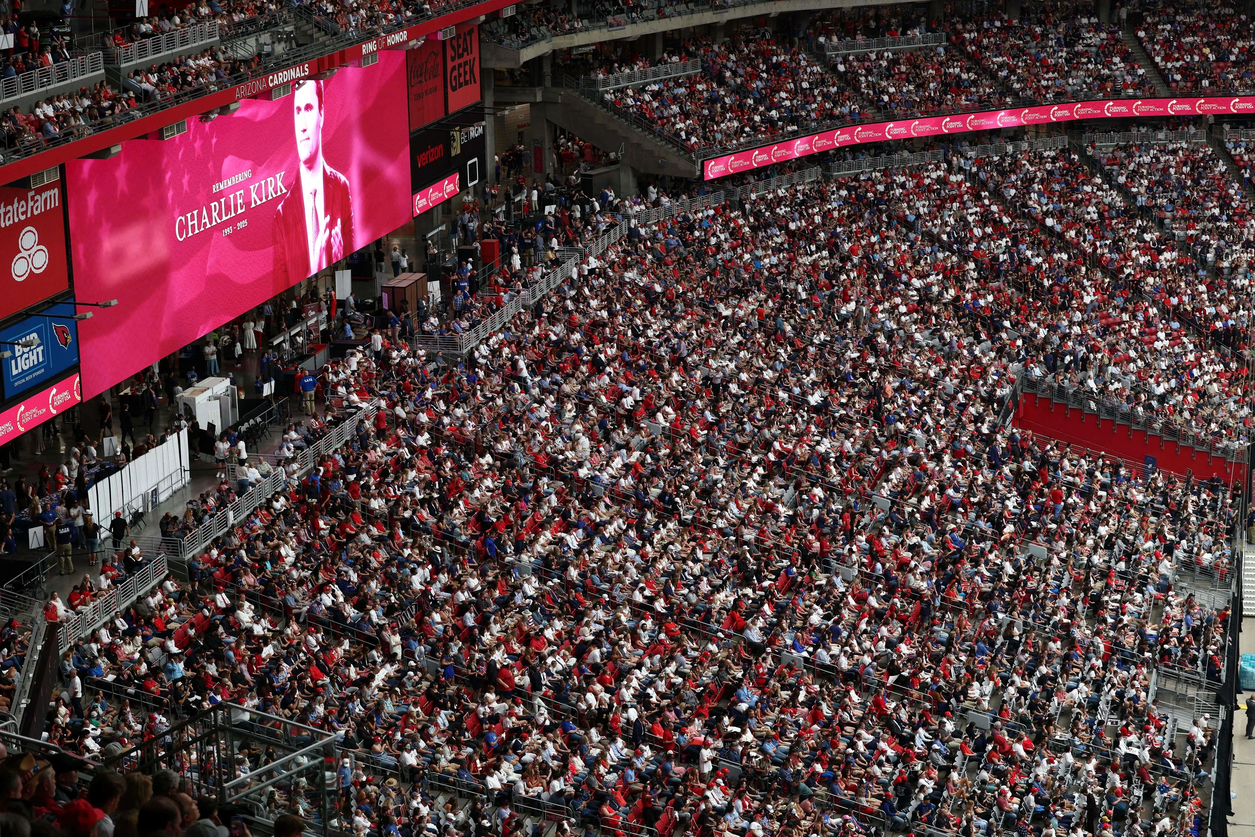 An image of right-wing activist Charlie Kirk is projected on a screen ahead of his public memorial service at State Farm Stadium in Glendale, Arizona | Photo: AFP