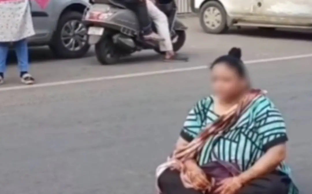 റോഡില് കുത്തിയിരുന്ന് പ്രതിഷേധിക്കുന്ന സ്ത്രീ | Screengrab Courtesy: x.com/GujaratTak