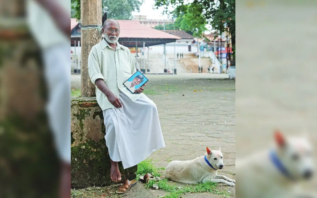 തിരുനക്കര ക്ഷേത്രത്തിന് മുന്നിൽ രവി, കാണാതായ മകന്റെ ഫോട്ടോയുമായി. ടൗണിലെത്തിയാൽ രവിക്കൊപ്പം കൂടുന്ന നായയെയും കാണാം |ഫോട്ടോ: ജി. ശിവപ്രസാദ്