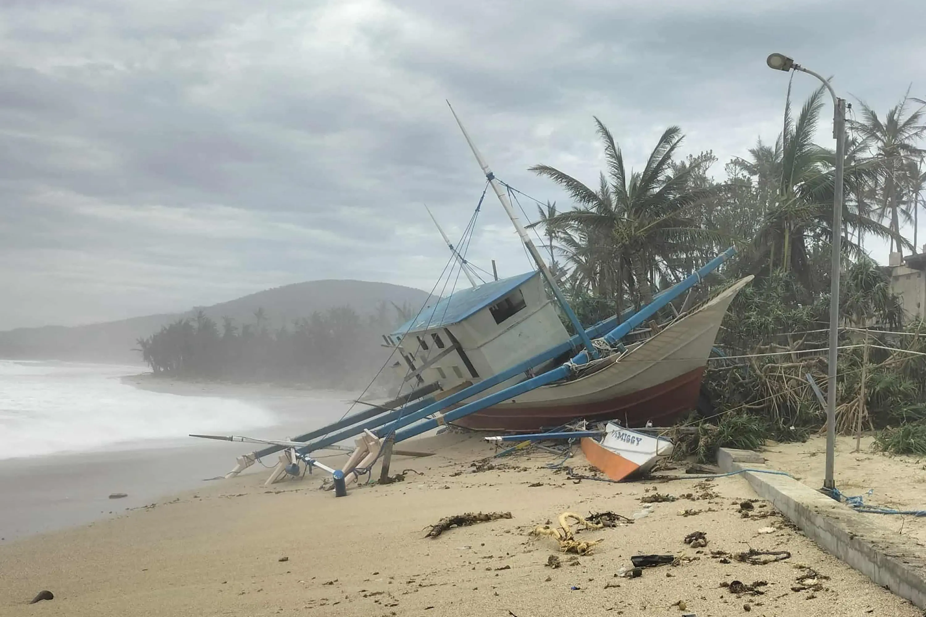 A fishing boat is seen washed ashore in Calayan island, Cagayan province, a day after Super Typhoon Ragasa hit the island | Photo: AFP