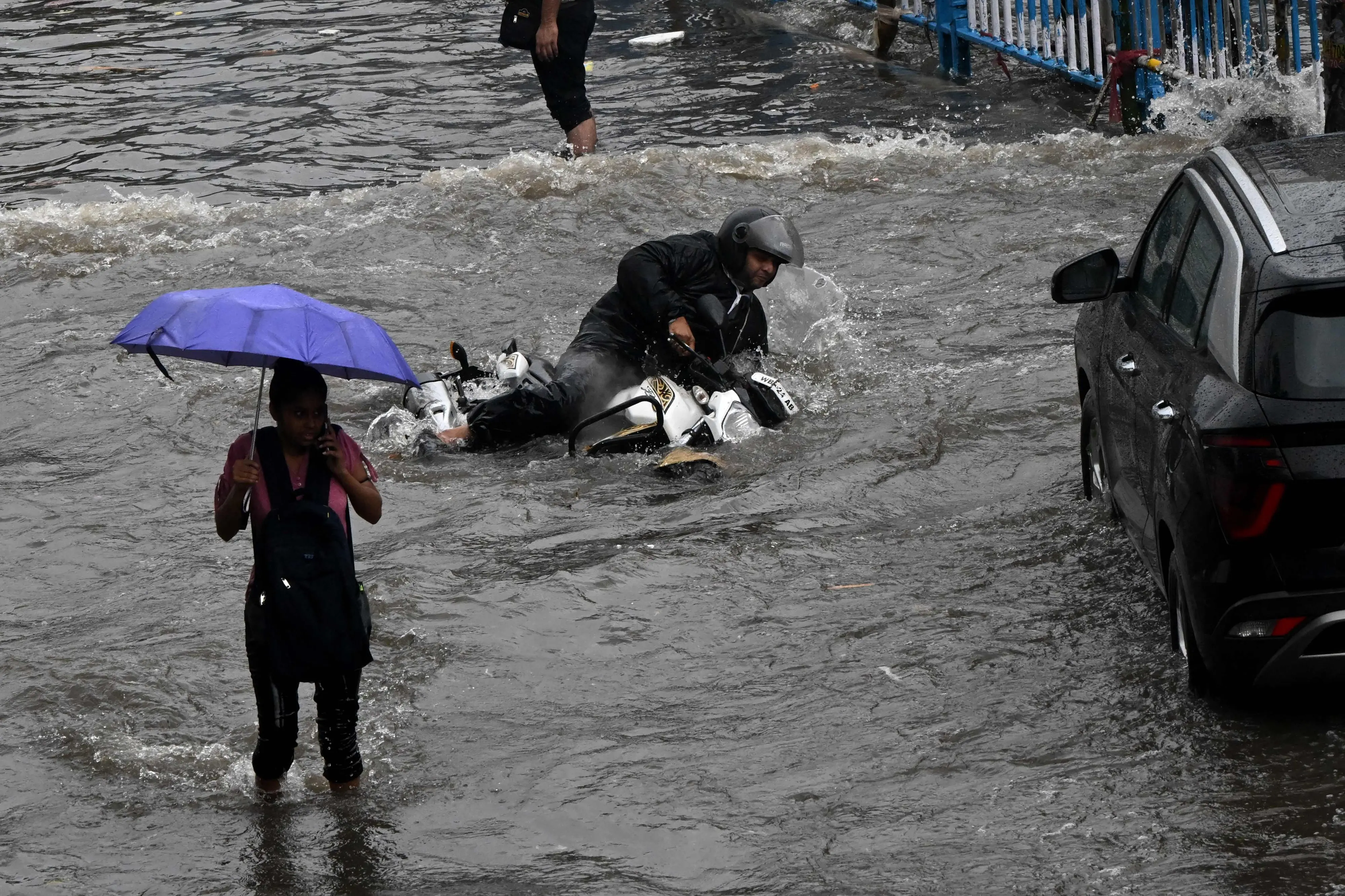 A motorist falls amidst a waterlogged road after heavy monsoon rains in Kolkata | Photo: AFP