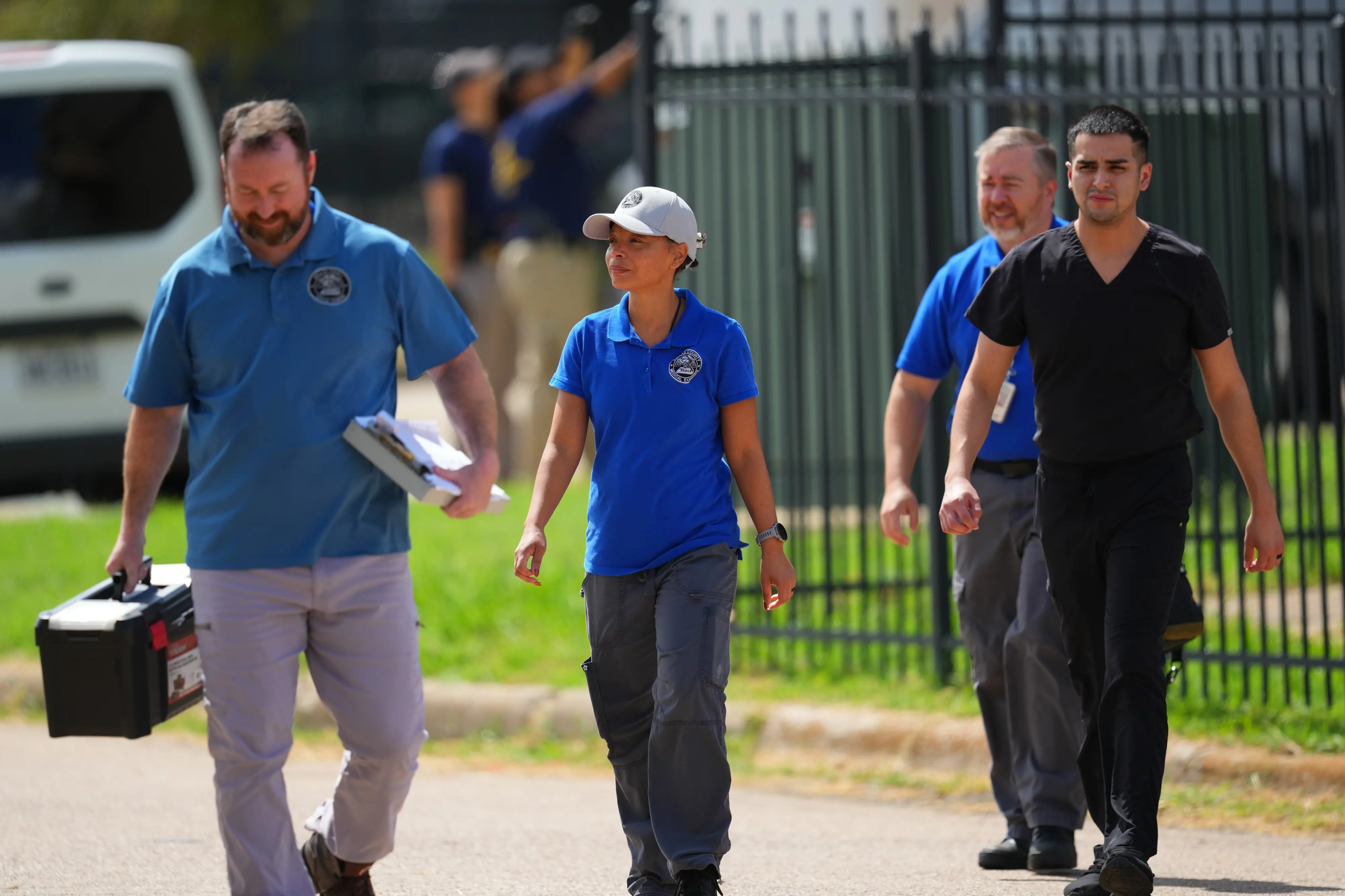 Medical examiners leave the apartment building near the scene of a shooting at a US Immigration and Customs Enforcement office in Dallas | Photo: AP