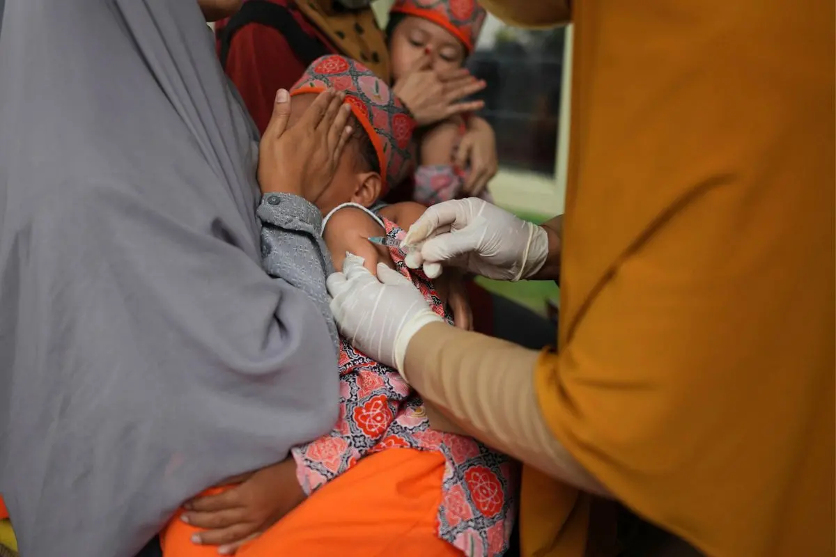 Health worker administers measles shot during a vaccination campaign | Photo: AP