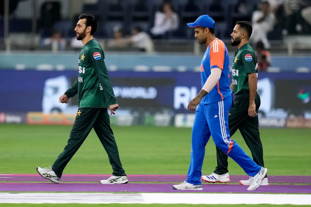 Pakistan's captain Salman Agha, left, and India's captain Suryakumar Yadav, center, walk out on to the field for the national anthems before the Asia Cup cricket final between India and Pakistan | Photo: AP