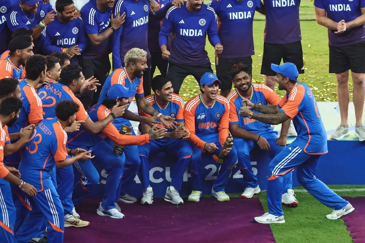 India's captain Suryakumar Yadav (R) playfully pretends to hold the trophy as his team celebrates their victory at the end of the Asia Cup 2025 Twenty20 international cricket final match between India and Pakistan at the Dubai International Stadium in Dubai | Photo: AFP