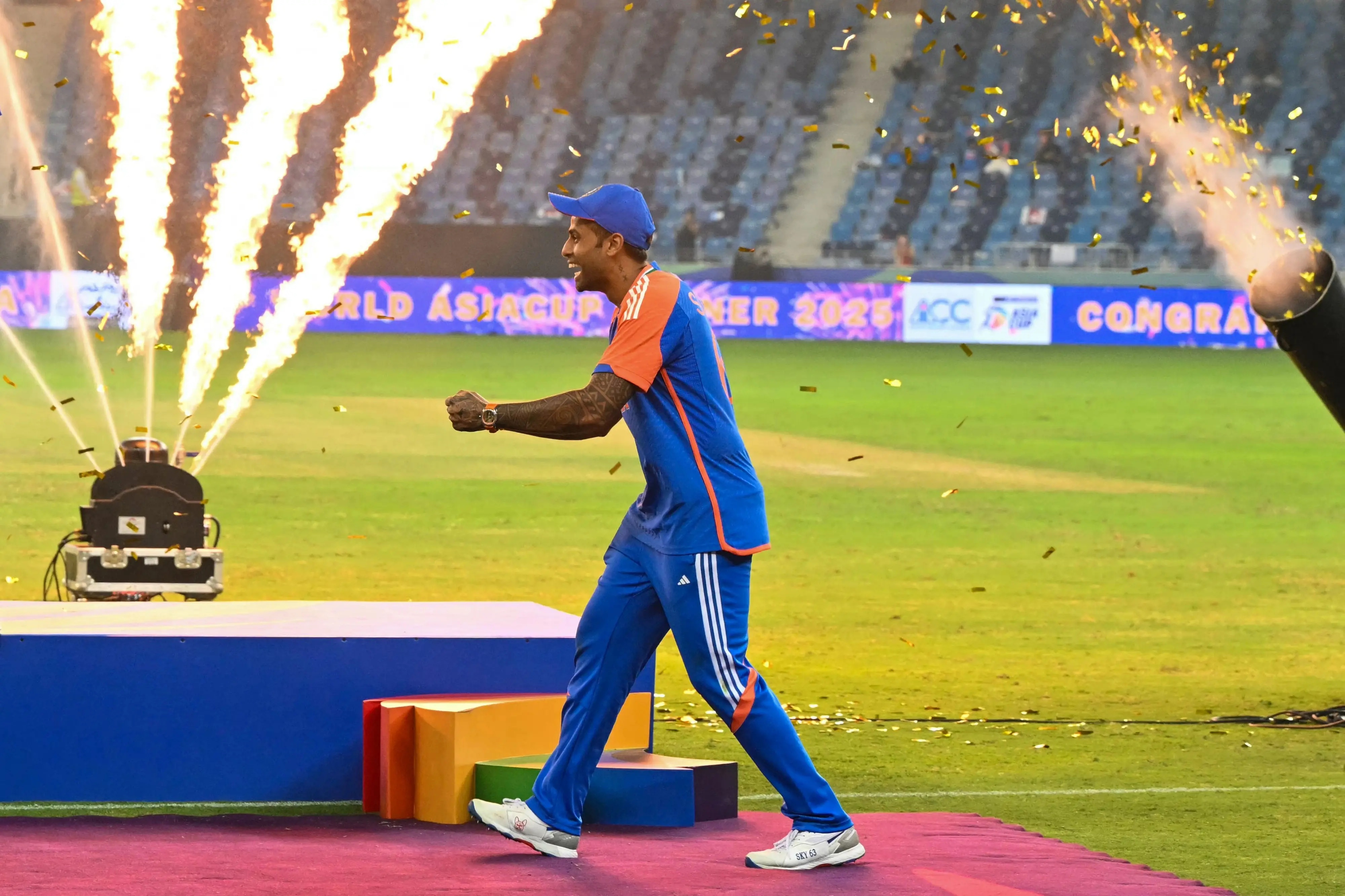 India's captain Suryakumar Yadav playfully pretends to hold the trophy as his team celebrates their victory at the end of the Asia Cup 2025 Twenty20 international cricket final match. | Photo: AFP