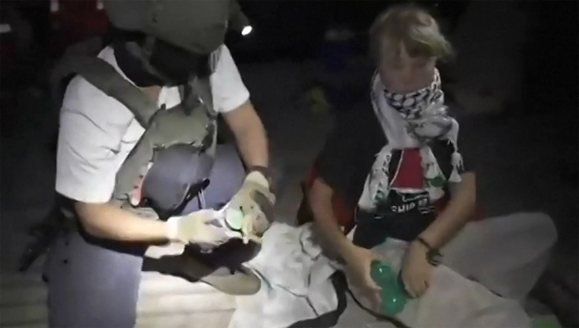 This video grab taken from a handout footage released by the Israeli Foreign Ministry on October 1, 2025 shows an Israeli soldier with Swedish climate activist Greta Thunberg (R) | Israeli Foreign Ministry / AFP)