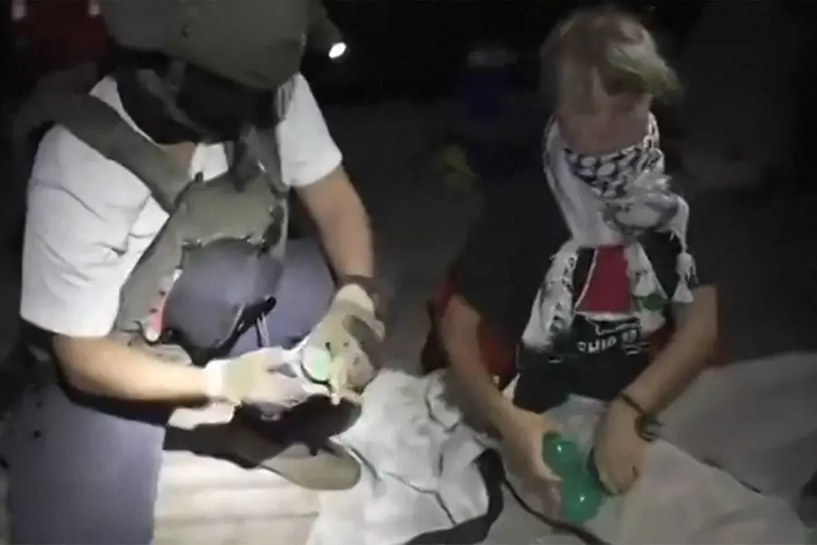 This video grab taken from a handout footage released by the Israeli Foreign Ministry on October 1, 2025 shows an Israeli soldier with Swedish climate activist Greta Thunberg (R)
