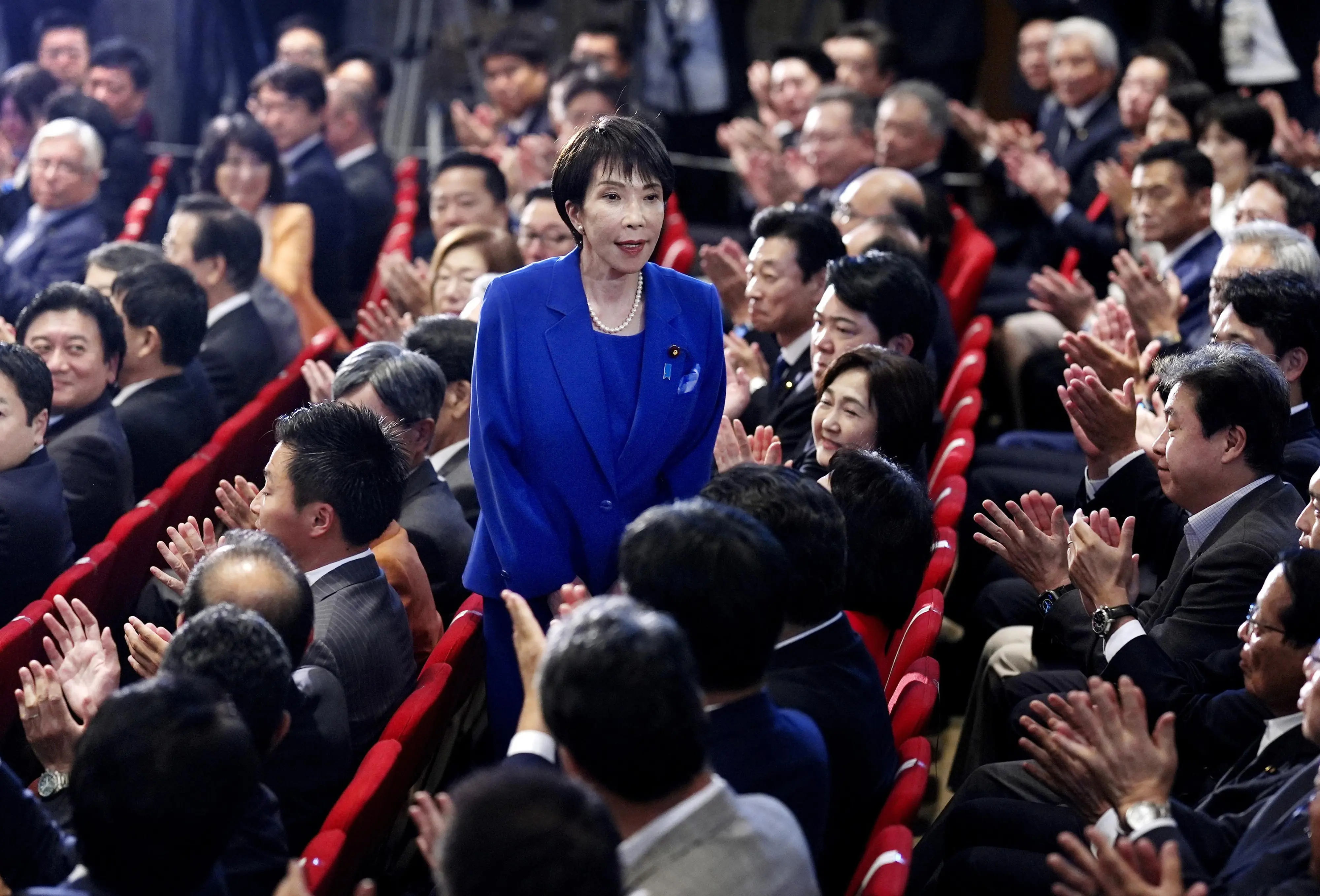 Former Economic Security Minister Sanae Takaichi, center, stands as Takaichi was chosen to a new leader of Japan's ruling Liberal Democratic Party during the party's leadership election in Tokyo, Japan. | Photo: AP