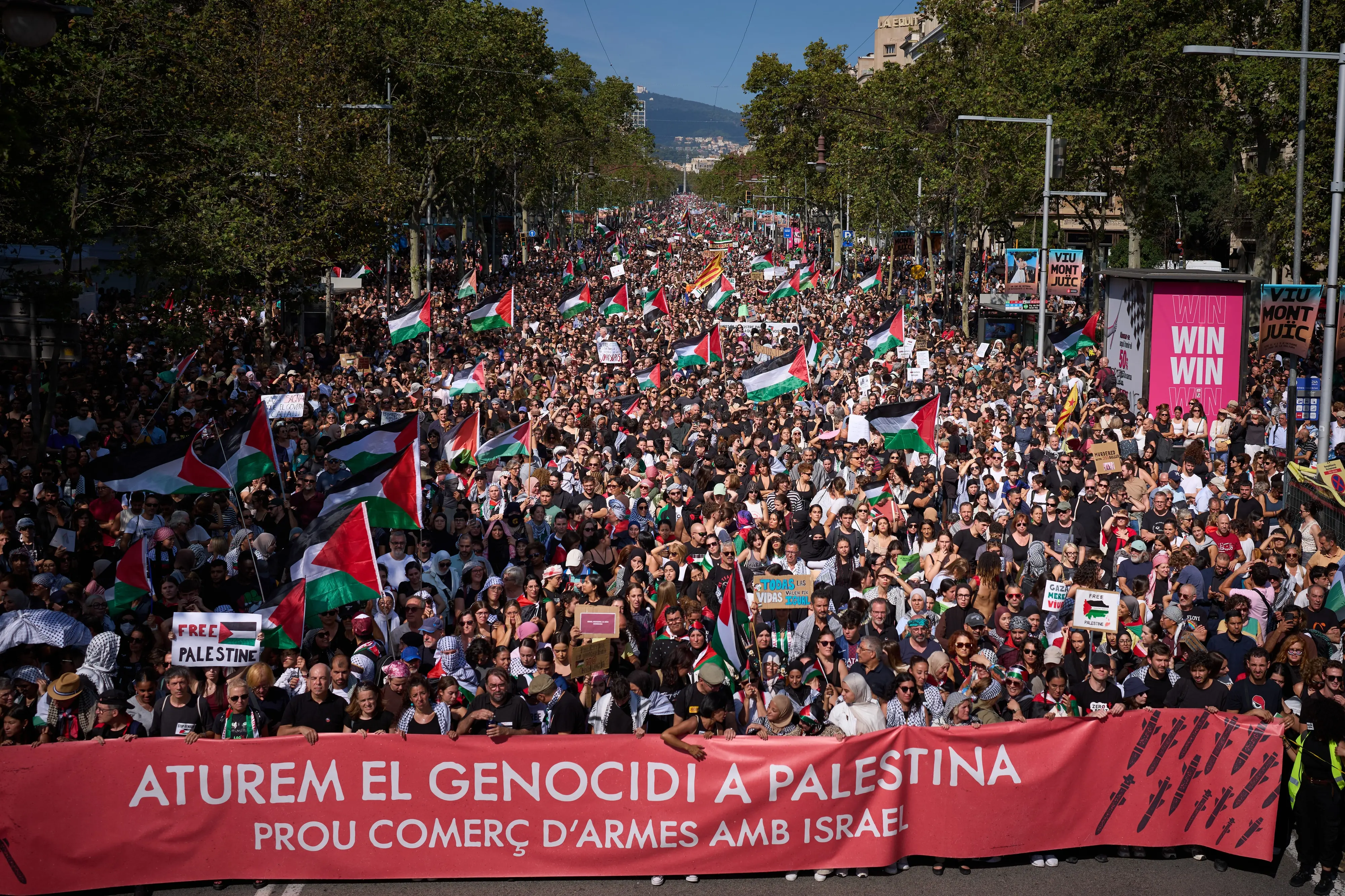 Demonstrators hold a banner with writing reading in Catalan "Let's stop the genocide in Palestine, no more arms trade with Israel" during a pro-Palestinian rally in solidarity with the Global Sumud Flotilla after ships were intercepted by the Israeli navy in Barcelona | Photo: AP