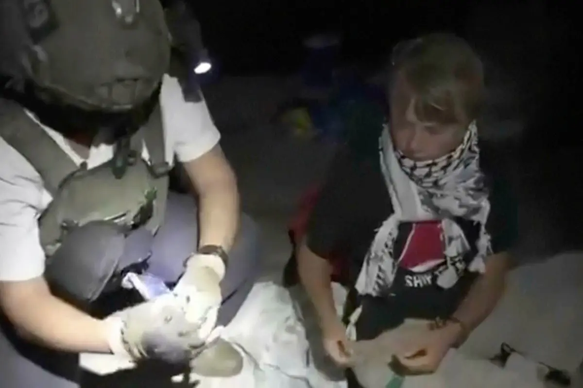 This image taken from video released by the Israeli Foreign Ministry claims to show activist Greta Thunberg, right, as she is removed after the Israeli navy intercepted the Global Sumud Flotilla carrying humanitarian aid towards Gaza on Wednesday, Oct. 1, 2025. (Israeli Foreign Ministry via AP)
