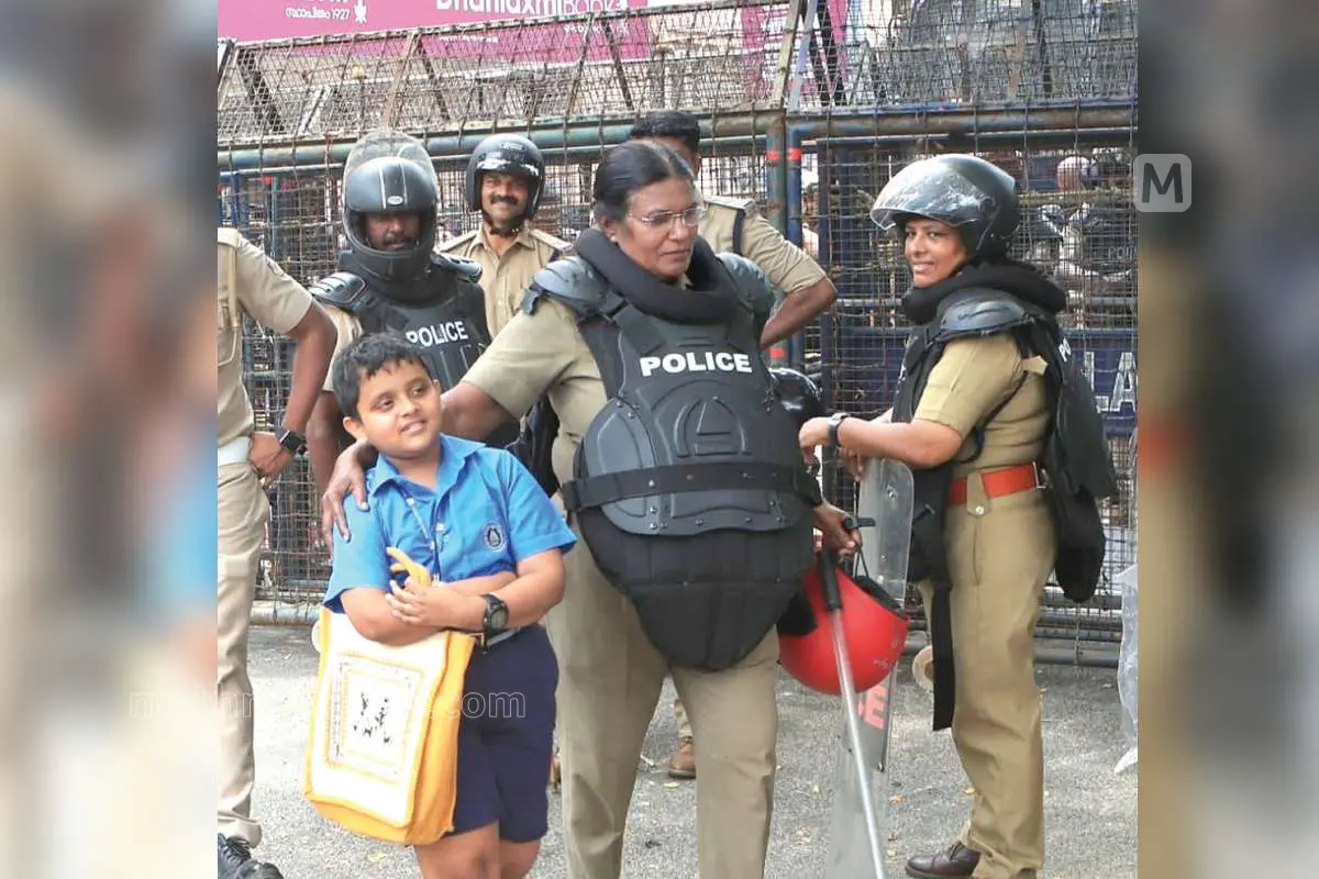 Govind, unable to go home due to the protest, stands near the barricade. A police officer consoles Govind nearby | Photo: Biju Varghese