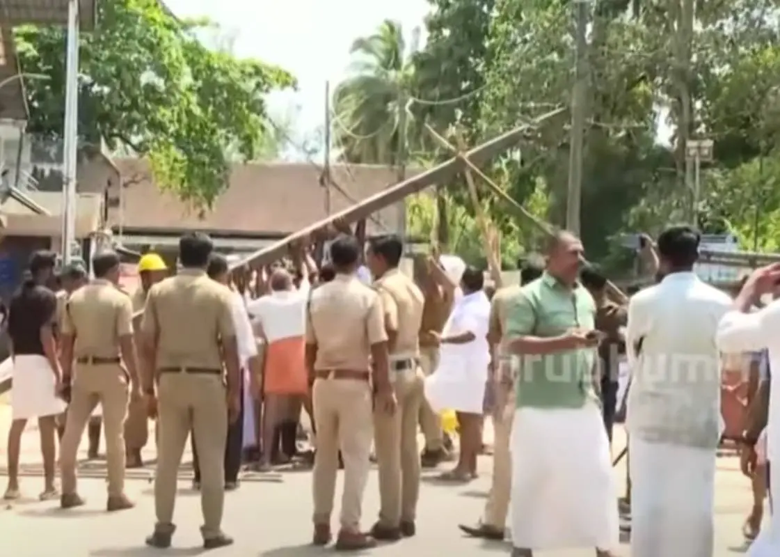 യൂത്ത് കോൺഗ്രസ് പ്രതിഷേധത്തിനിടെ ഒടിഞ്ഞുവീഴാറായ വൈദ്യുതി പോസ്റ്റ് പോലീസും യൂത്ത് കോൺഗ്രസ് പ്രവര്ത്തകരും ചേര്ന്ന് താങ്ങിപ്പിടിച്ചിരിക്കുന്നു | Photo: Screengrab / Mathrubhumi news