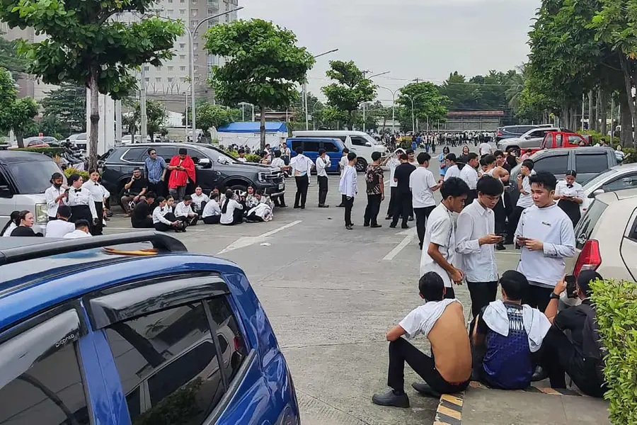Employees at a shopping mall gather outside the building in Davao City, on the southern island of Mindanao on October 10, 2025, after a 7.4-magnitude earthquake struck off the southern Philippines.