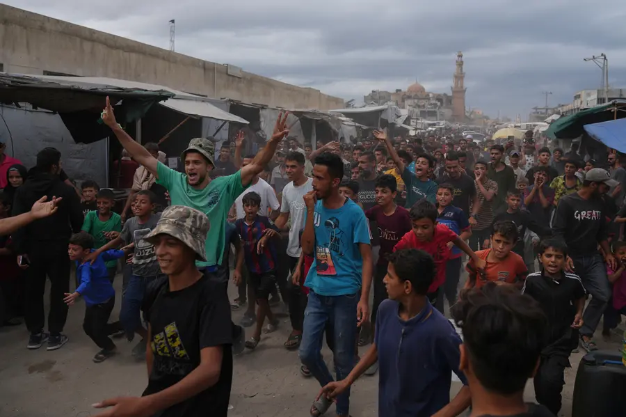 Palestinians celebrate following the announcement that Israel and Hamas have agreed to the first phase of a peace plan to pause the fighting, in Khan Younis, southern Gaza Strip