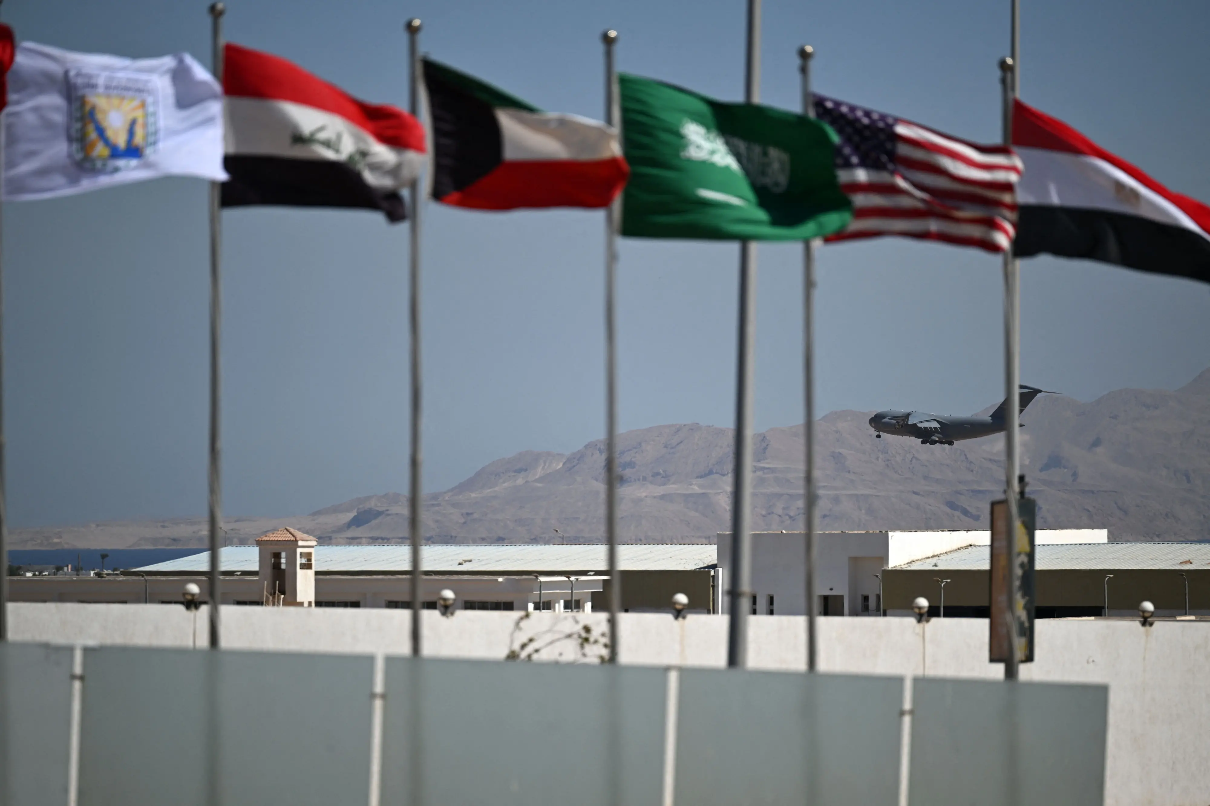 Flags of several countries flutter as a US military aircraft prepares to land in Sharm el-Sheikh, ahead of the arrival of international leaders to the Egyptian Red Sea resort, following a Gaza ceasefire agreement | AFP
