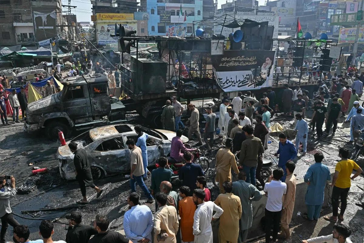 Locals look at the remains of charred vehicles following violent clashes between police personnel and anti-Israel protesters from the Tehreek-e-Labbaik Pakistan (TLP) party in Muridke
