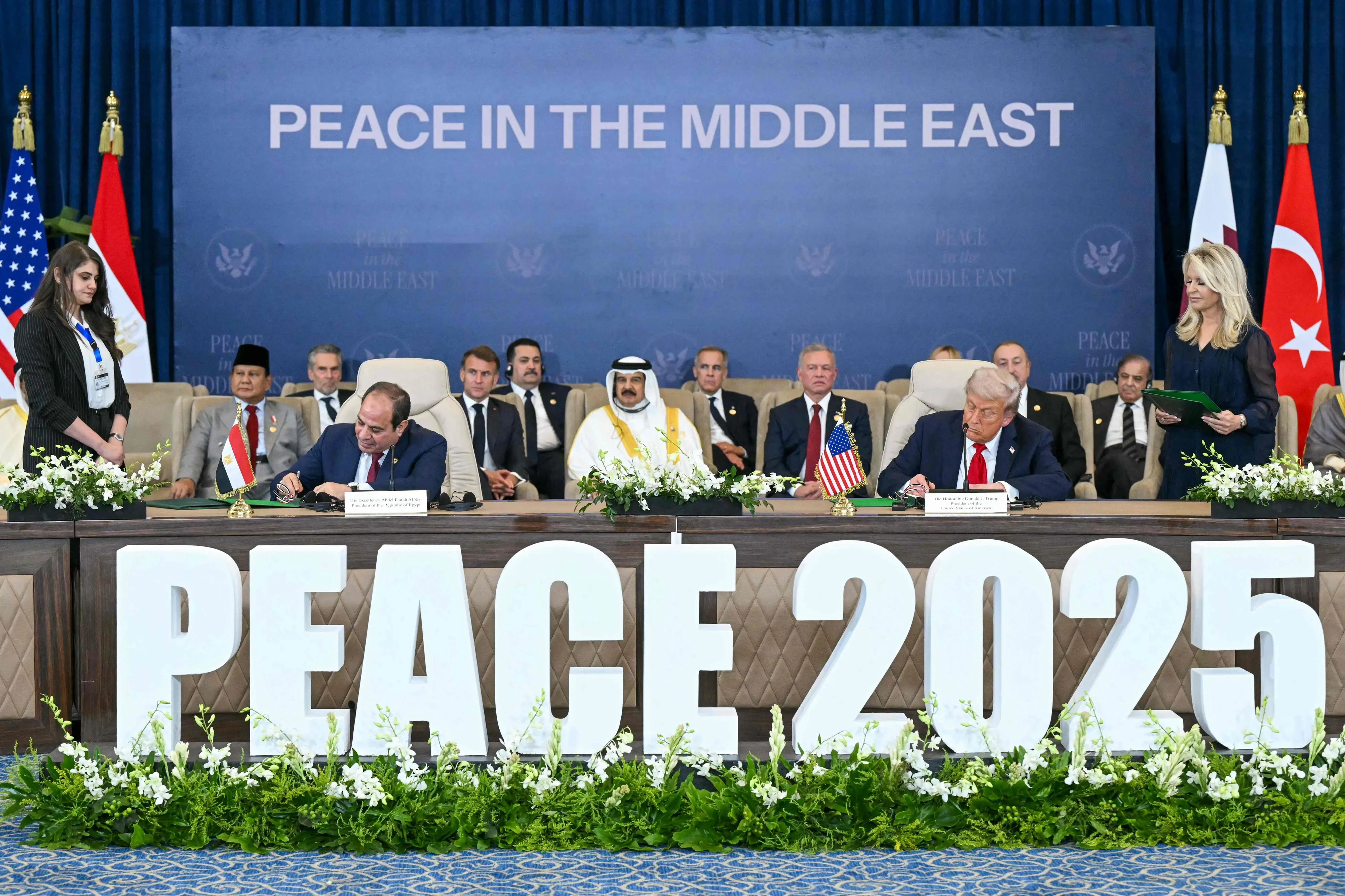 US President Donald Trump (R) and Egypt's President Abdel Fattah al-Sisi sign documents during a summit on Gaza in Sharm el-Sheikh on October 13, 2025. | Photo: AFP