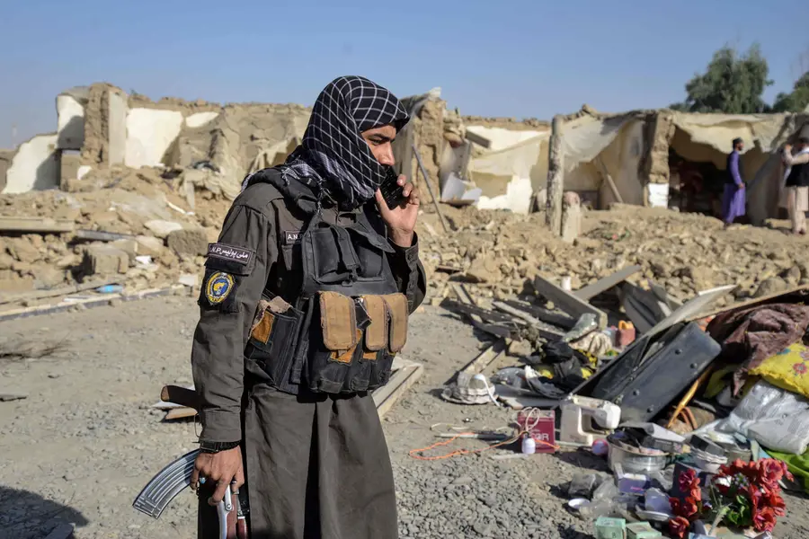 A Taliban security personnel stands near a damaged house in the Spin Boldak district of Kandahar province