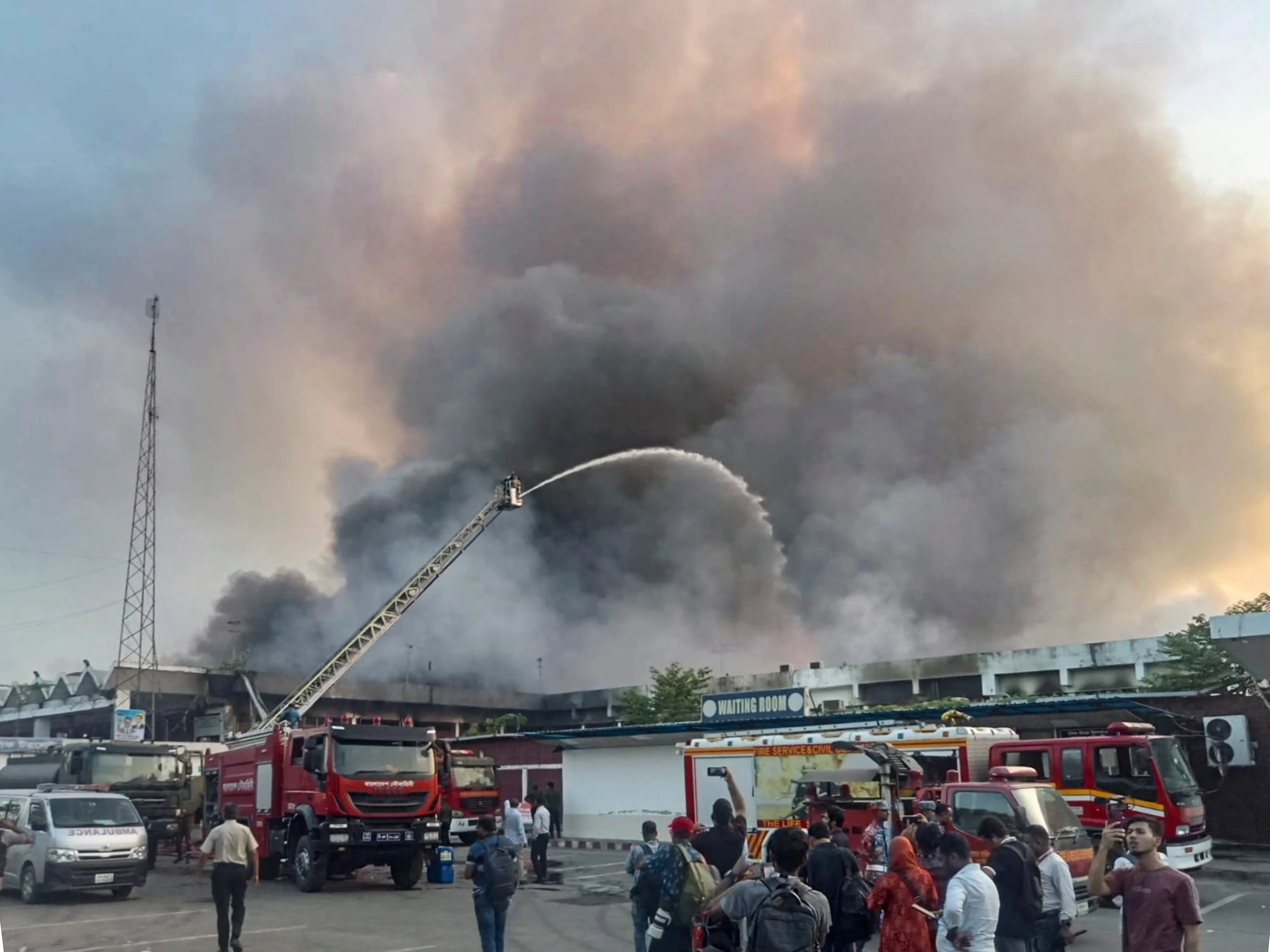 Firemen douse a fire as smoke billows from fire breaking out at the cargo complex of the Hazrat Shahjalal International Airport, in Dhaka. | Photo: AP