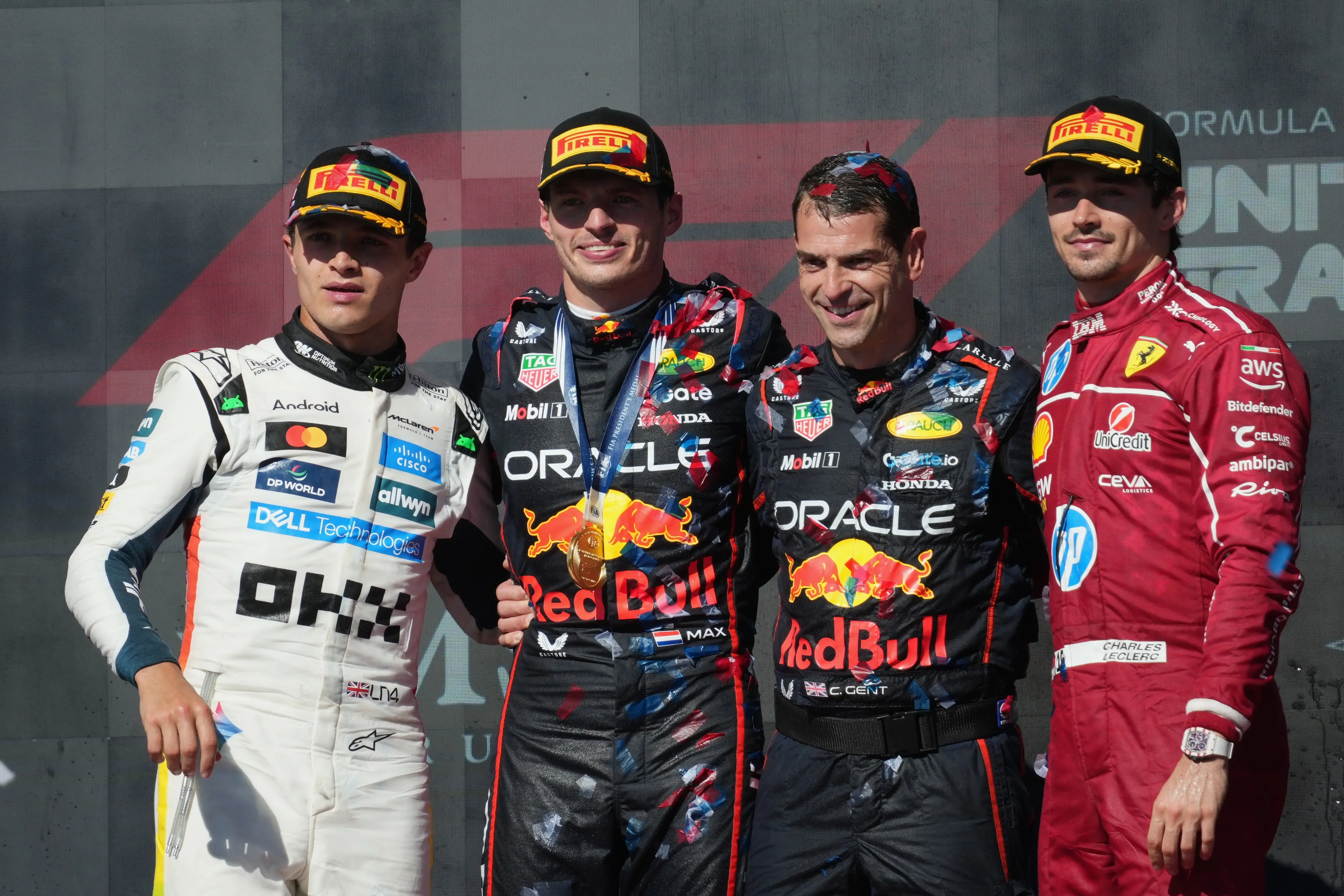 Winner Red Bull driver Max Verstappen of the Netherlands, second left, poses on the podium with second placed McLaren driver Lando Norris of Britain, left, third placed Ferrari driver Charles Leclerc of Monaco, right, and Red Bull team mechanic Chris Gent, second right, after the Formula One U.S. Grand Prix auto race in Austin, Texas, Sunday, Oct. 19, 2025. | Photo: AP