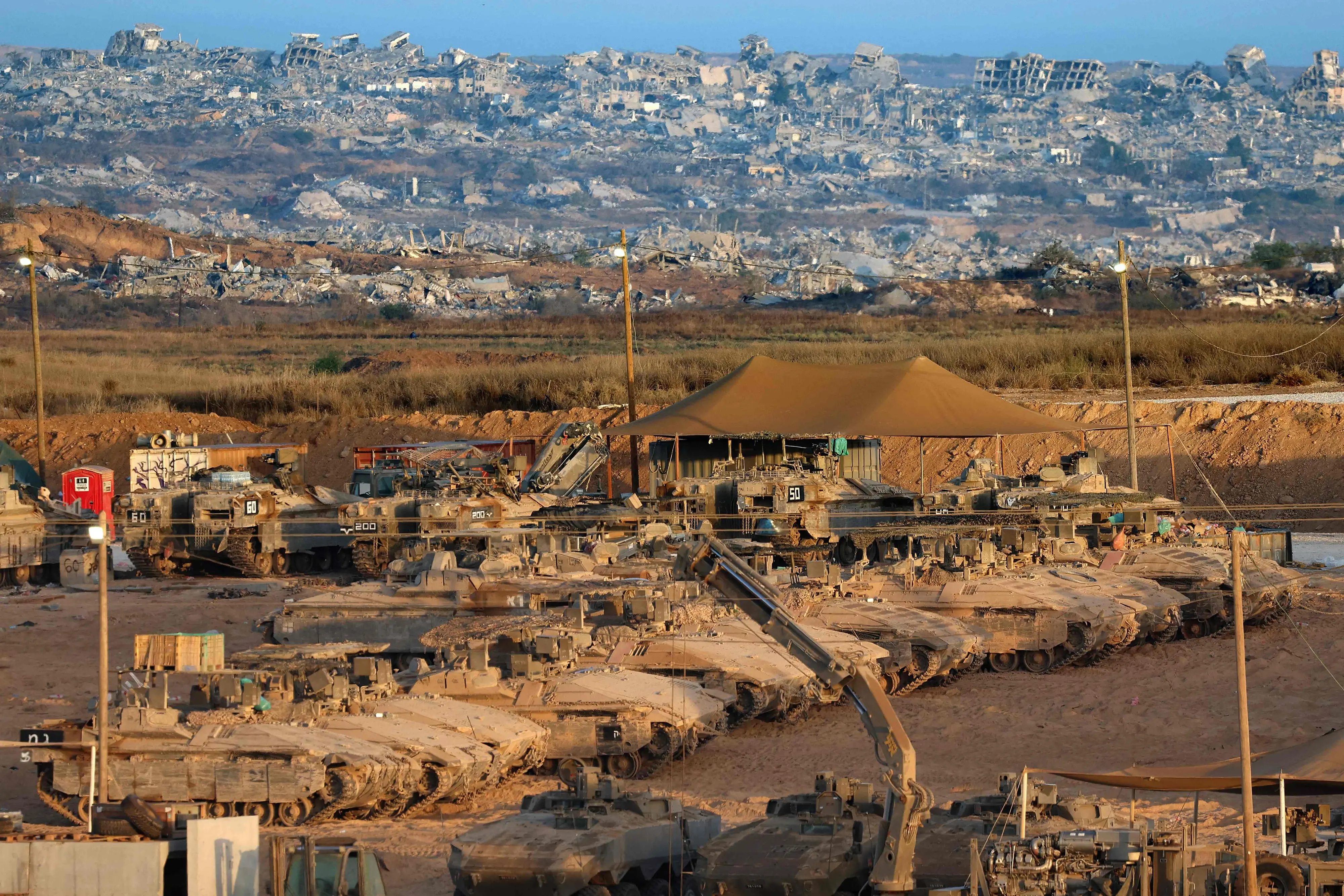 Israeli army tanks are positioned along the border fence between Israel and the Gaza Strip | AFP