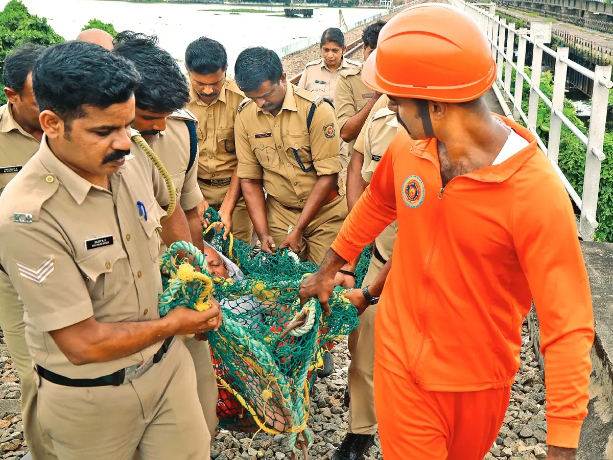 റെയിൽവേ പാലത്തിന്റെ ഗർഡറിനടിയിൽ ആറാം തൂണിൽ മദ്യപിച്ച് ഉറങ്ങിക്കിടന്ന കന്യാകുമാരി സ്വദേശി ഷാജിയെ പോലീസും അഗ്നിരക്ഷാ സേനാംഗങ്ങളും കൂടി രക്ഷപ്പെടുത്തി കൊണ്ടുവരുന്നു