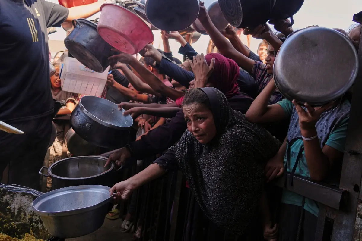 Palestinians struggle to get donated food at a community kitchen in Khan Younis, southern Gaza Strip | Photo: AP