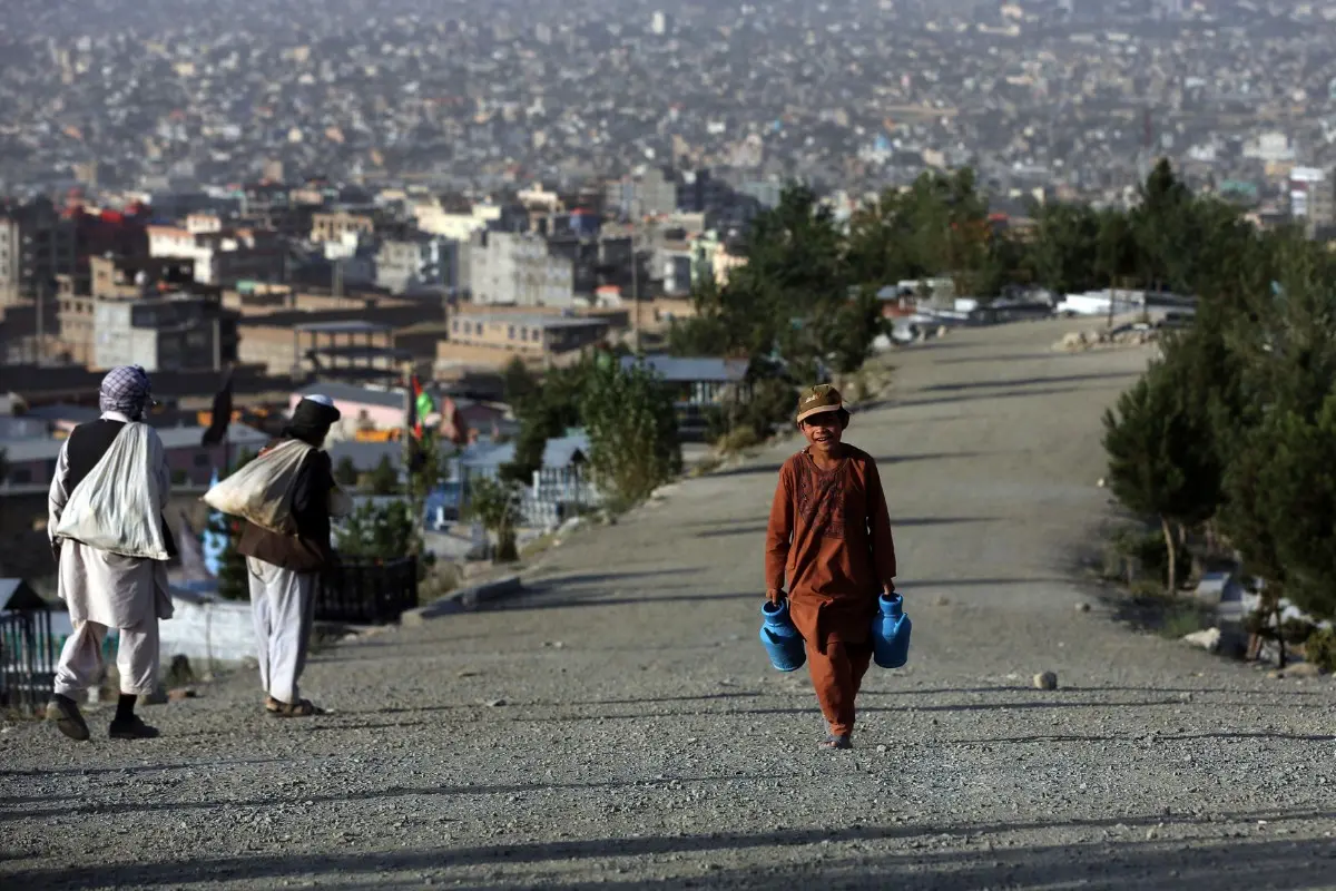 A boy carries jugs of water to sell | File Photo: AFP