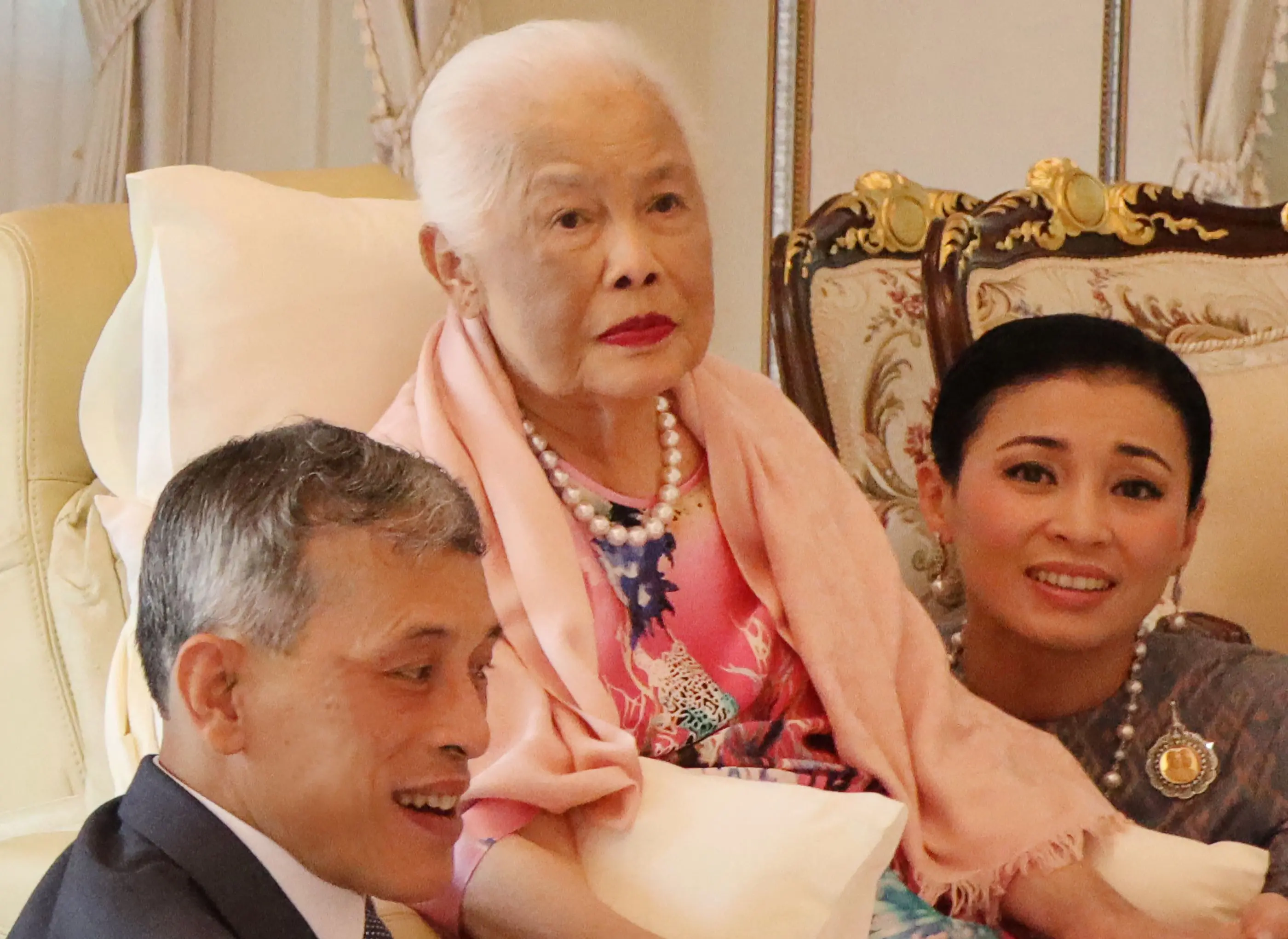 Thailand's Queen Mother Sirikit (C) sitting with King Maha Vajiralongkorn (L) and Queen Suthida during a merit-making ceremony on her 87th birthday at Chitralada Palace in Bangkok | File photo: AFP