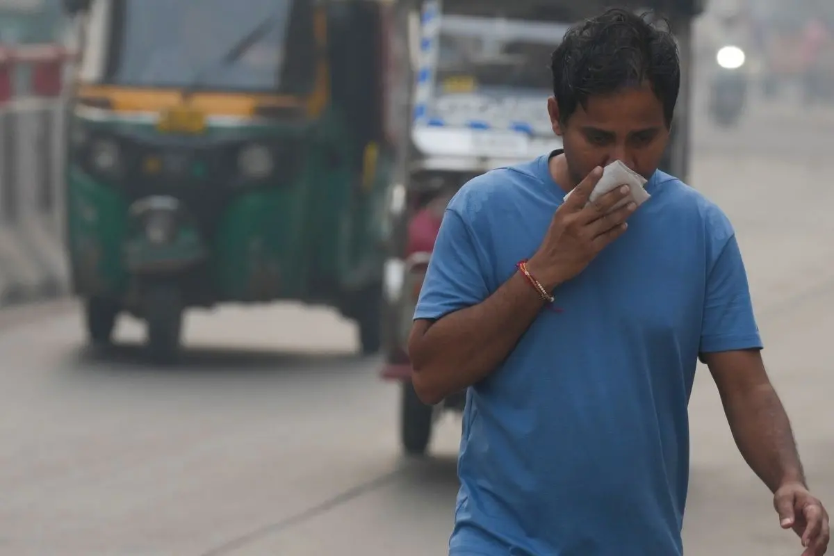 A commuter covers his face while making his way amid low visibility as air quality deteriorates across Delhi-NCR, in New Delhi (Photo: PTI)