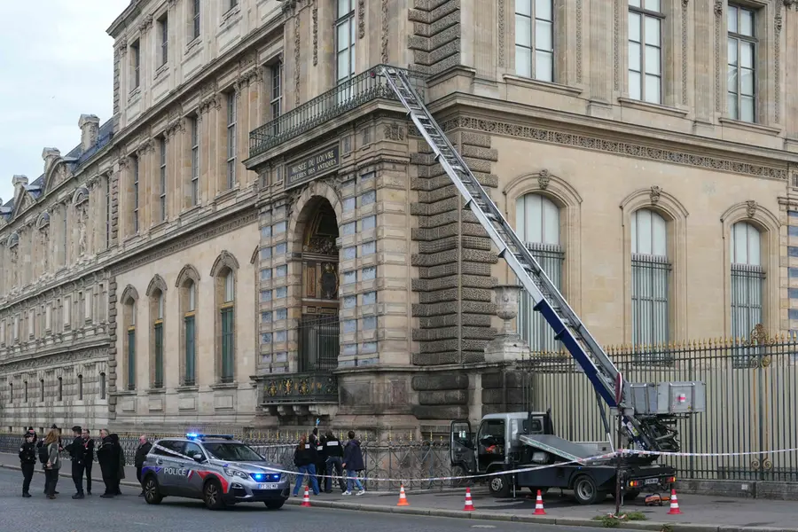 French police officers stand next to a furniture elevator used by robbers to enter the Louvre Museum