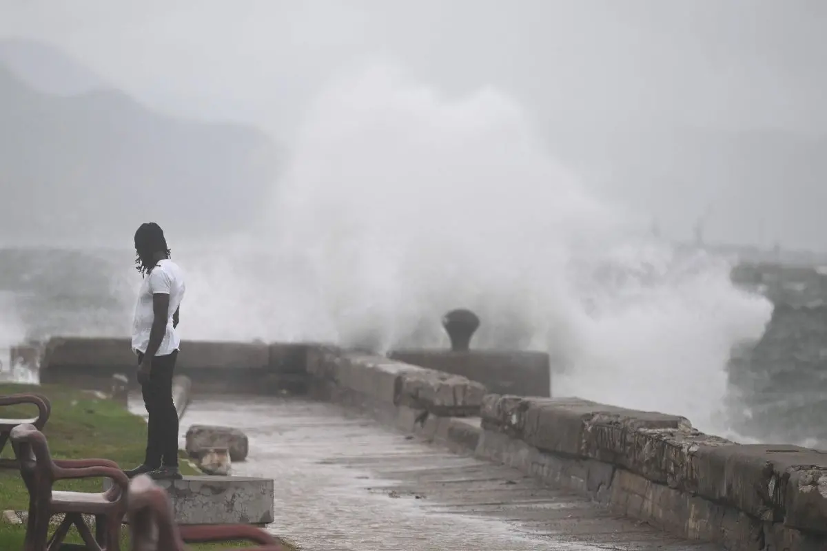A man watches the waves crash into the walls at the Kingston Waterfront. | Photo: AFP