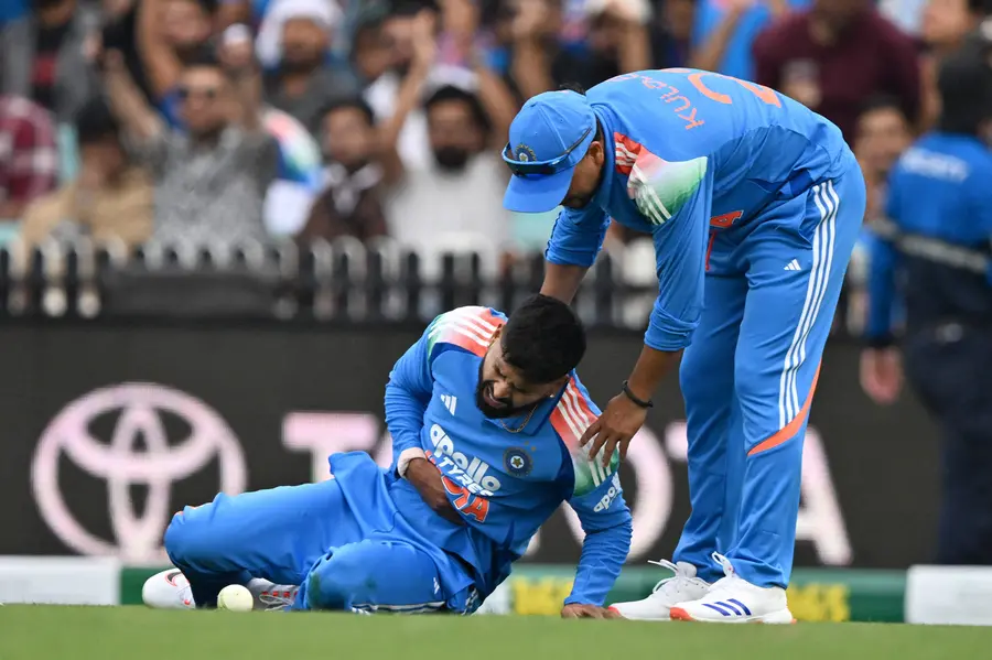 Shreyas Iyer (L) reacting in pain as he leaves the field during the third one-day international (ODI) men's cricket match between Australia and India