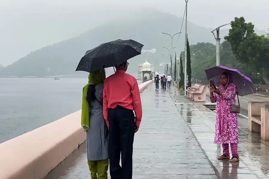 People click photos as they enjoy the rain at Fateh Sagar Lake in Udaipur