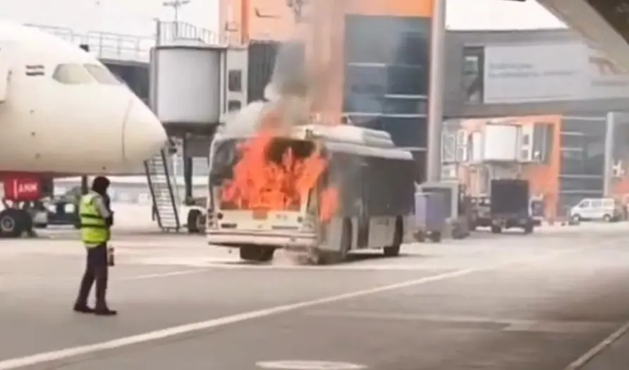A visual from the airport shows a bus engulfed in flames