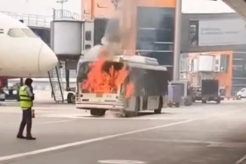 A visual from the airport shows a bus engulfed in flames.