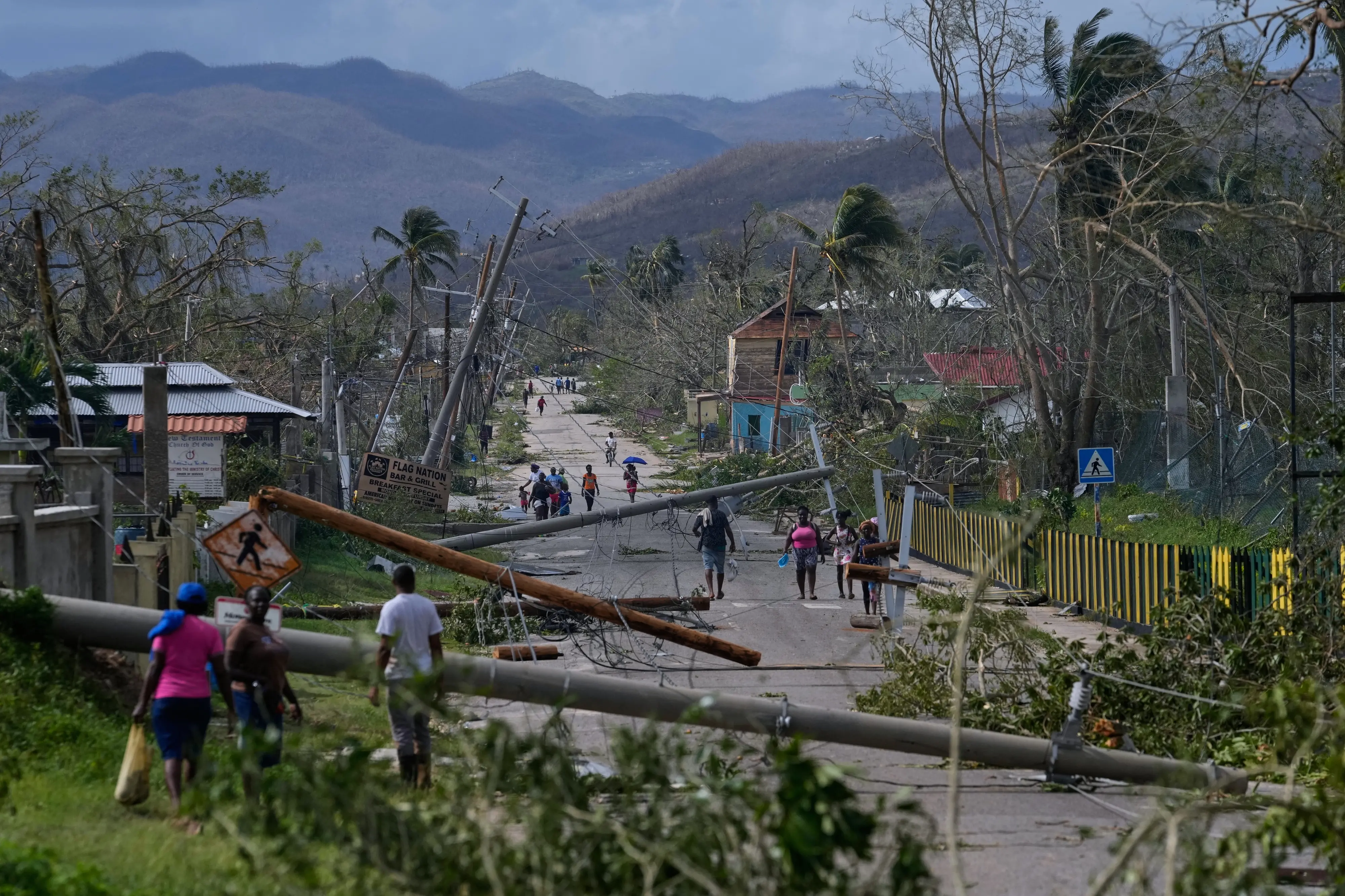 Residents walk through Lacovia Tombstone, Jamaica, in the aftermath of Hurricane Melissa | Photo: AP