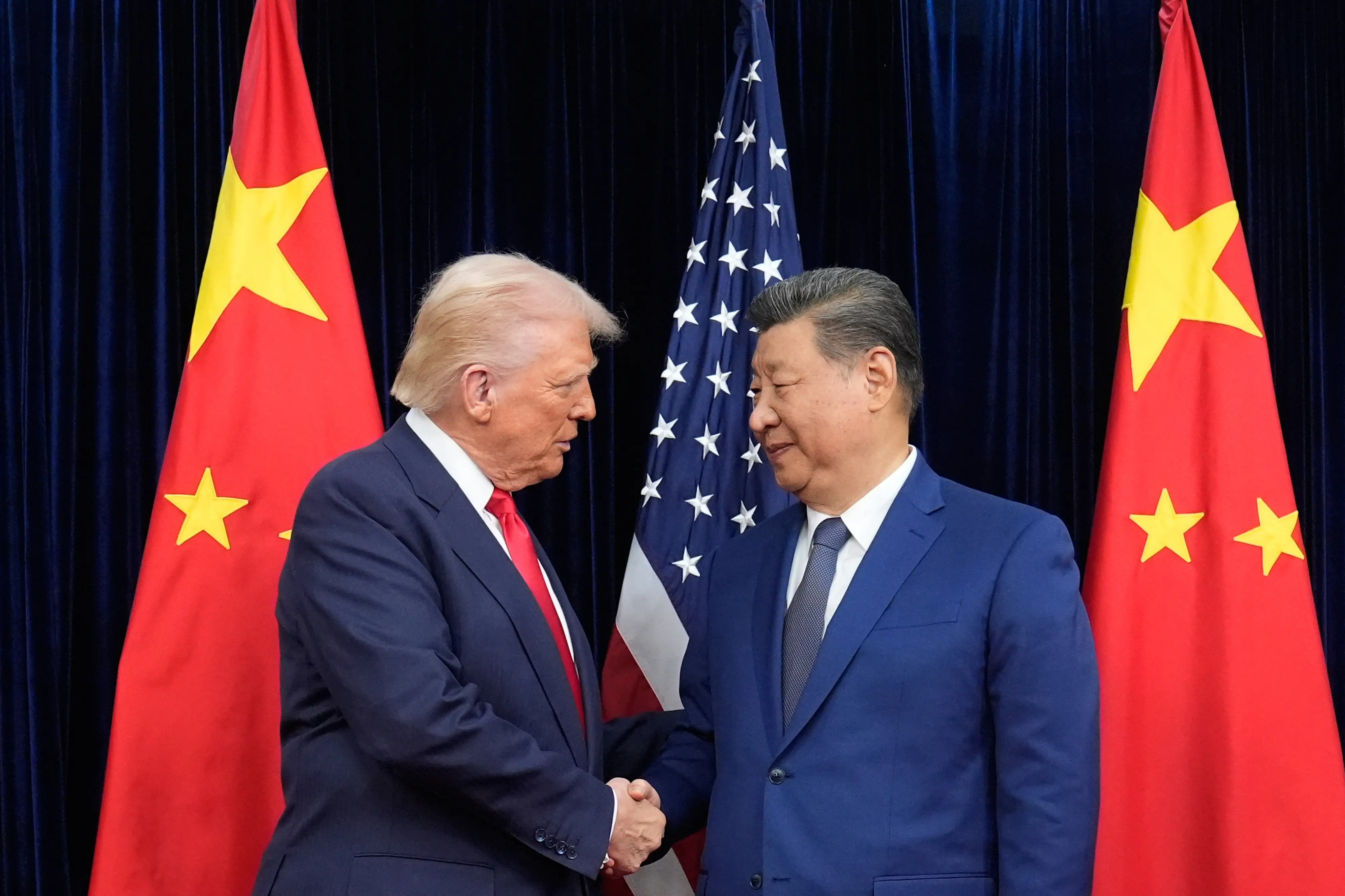 President Donald Trump, left, and Chinese President Xi Jinping, right, shake hands before their meeting at Gimhae International Airport in Busan | AP/PTI