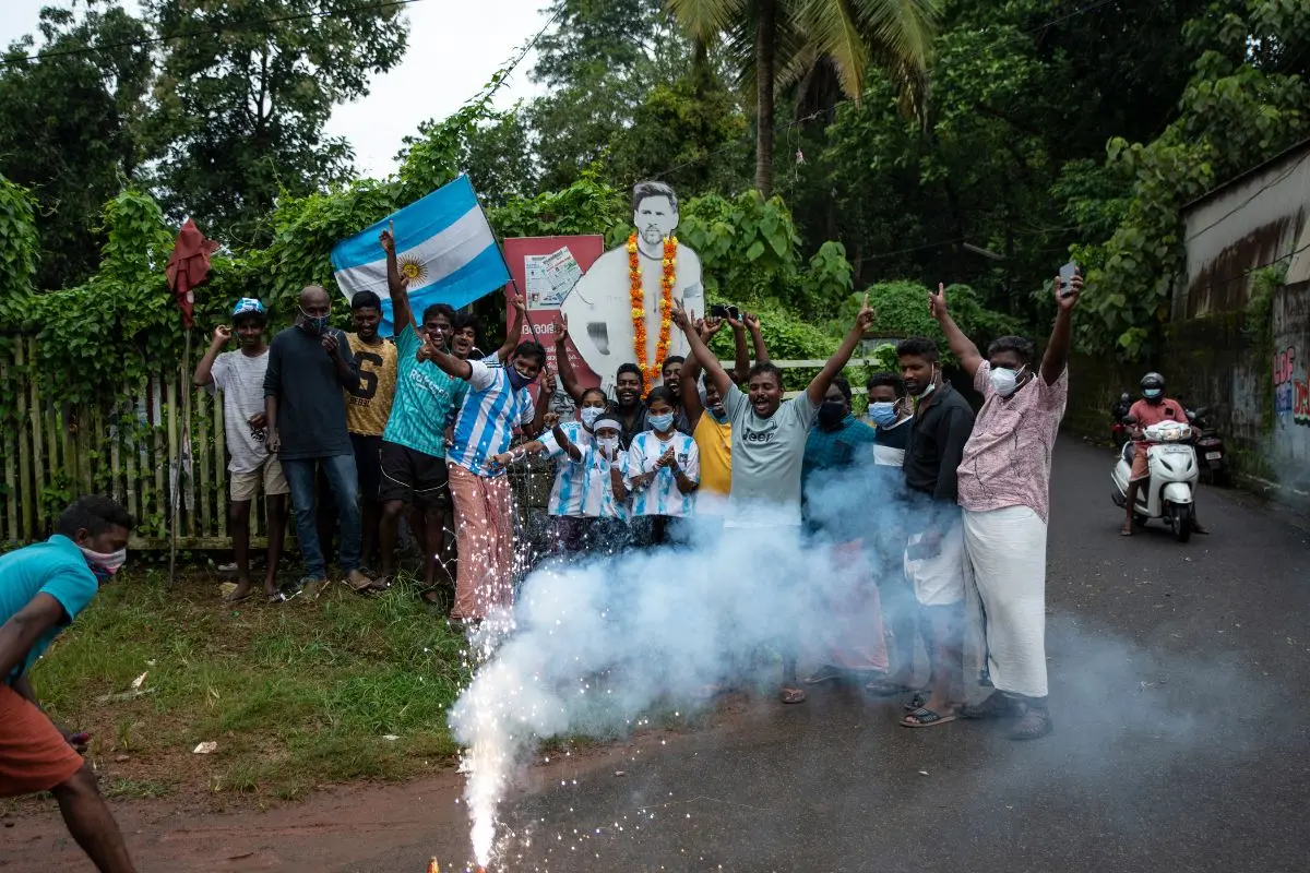 Kerala football fans garland a cut-out photograph of Lionel Messi and light firecrackers. (AP Photo/R S Iyer)