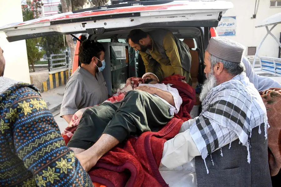 Afghan men assist an injured man into an ambulance in the aftermath of an earthquake, that struck overnight at Mazar-i-Sharif