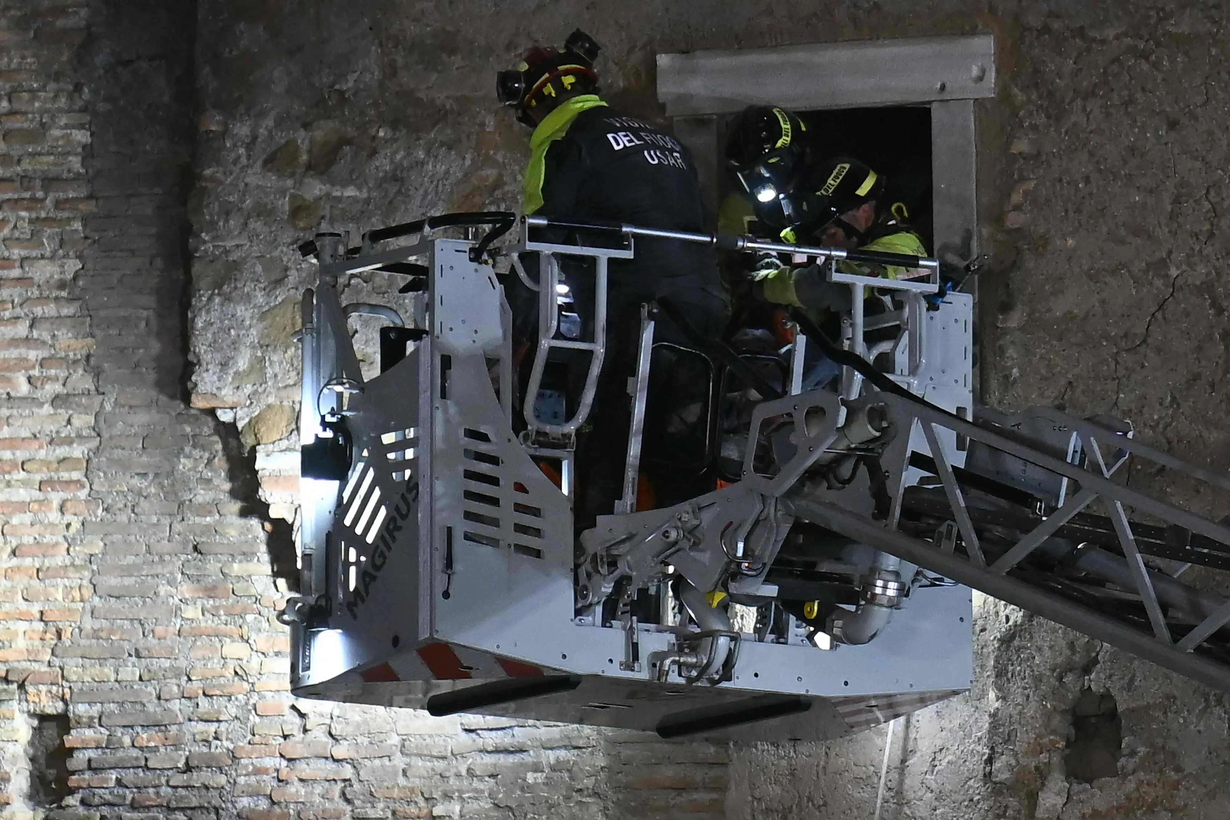 Rescuers evacuate the worker who was trapped in the medieval tower "Torre dei Conti" after the tower partially collapsed near the Roman Forum in the historic center of Rome | Photo: AFP