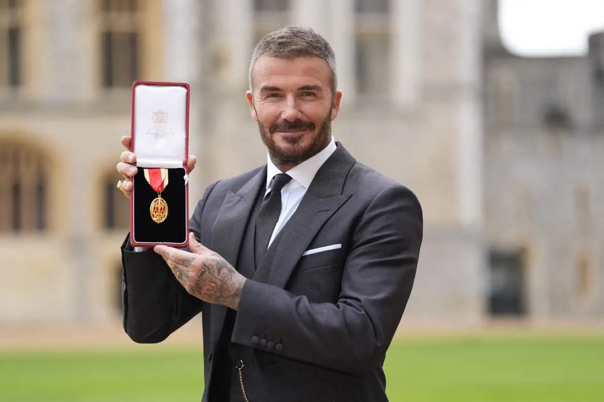 Former England footballer David Beckham poses with their medal after being appointed as a Knight Bachelor (Knighthood) | Photo: AFP