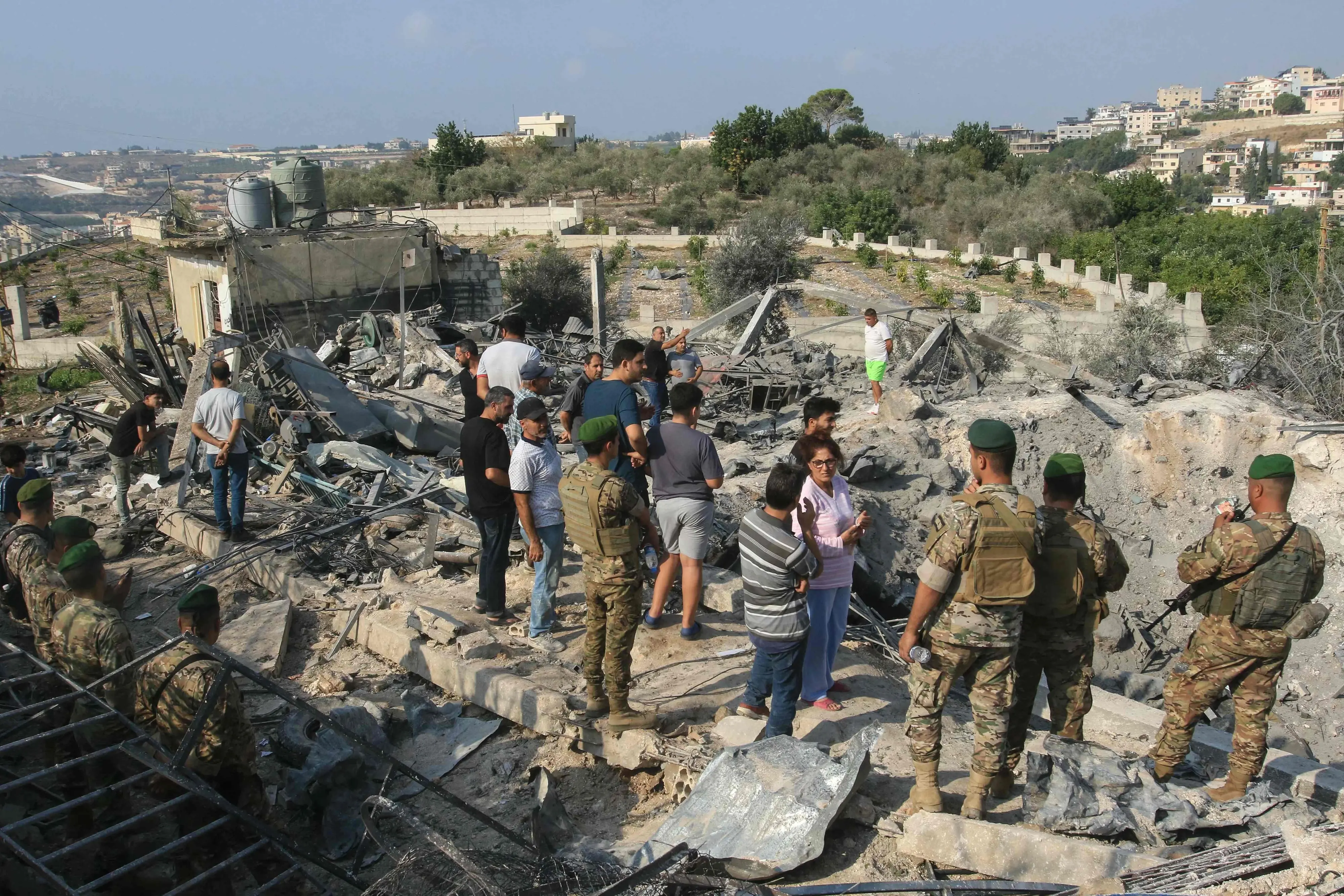 Lebanese soldiers and local residents stand at the site of an Israeli airstrike in the southern Lebanese village of Toura | Photo: AFP
