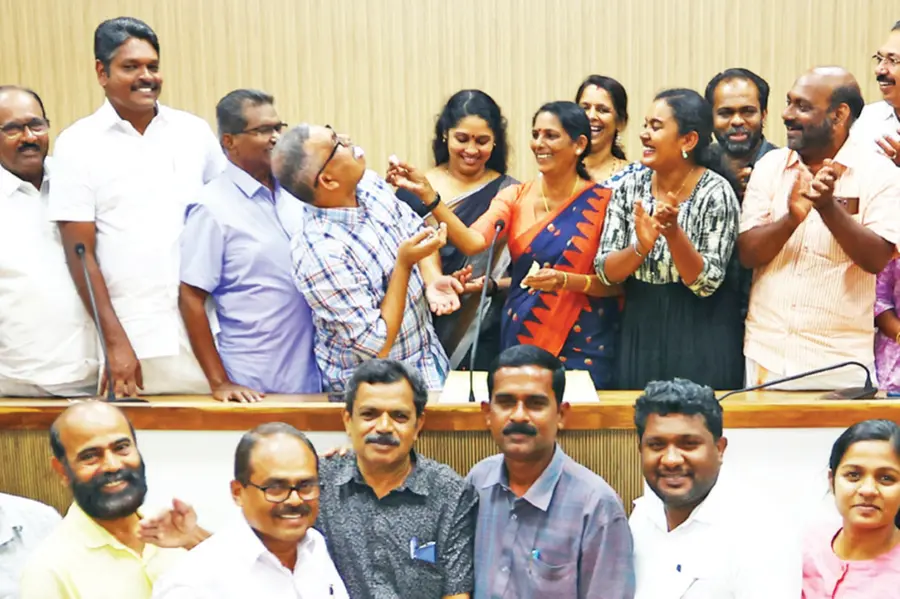 Alappuzha Municipal Council members cutting a cake and celebrating after the final council meeting
