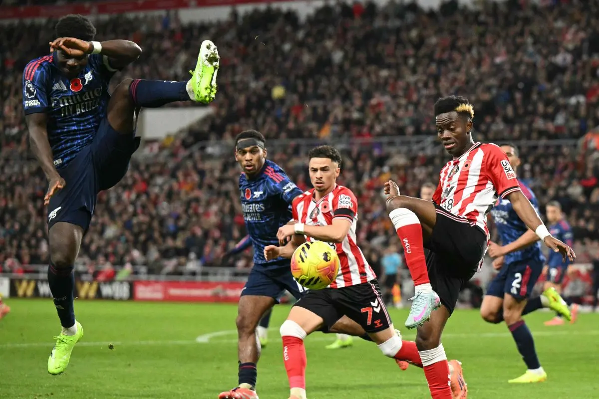 Sunderland's English Ivorian #24 Simon Adingra (R) kicks a clearance as Arsenal's English midfielder #07 Bukayo Saka (L) leaps to try to block | Photo: AFP